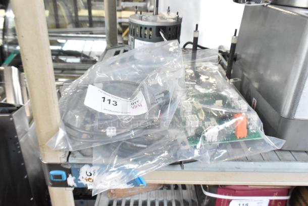 Brand new items including burner, KX-234-36, Pratica HW000110 circuit board, in bags. Auction tag 113 visible.