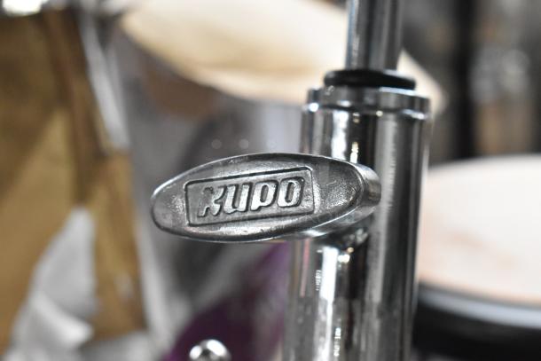 Close-up of Kupo Commercial Casters featuring a metallic body with the Kupo logo embossed on a chrome component.