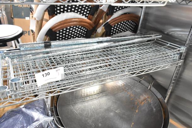 Wire shelves and poles set in metal, auction label 130, new condition, includes multiple rods and shelf units.
