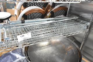 Wire shelves and poles set in metal, auction label 130, new condition, includes multiple rods and shelf units.