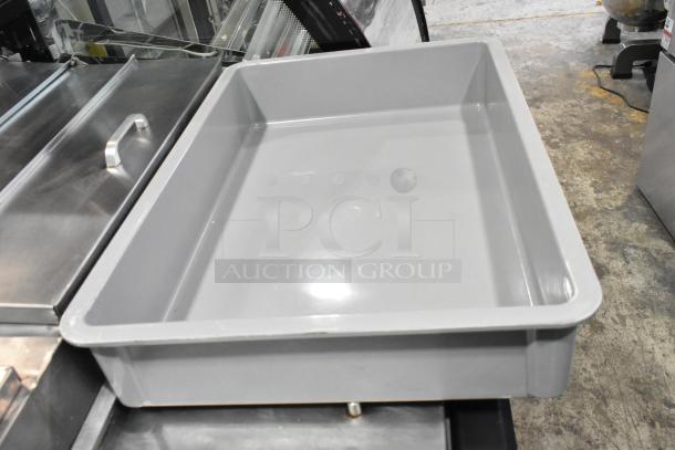 Gray poly dough bin in new condition, slight scratches, dent visible. Ideal for storage, durable construction.