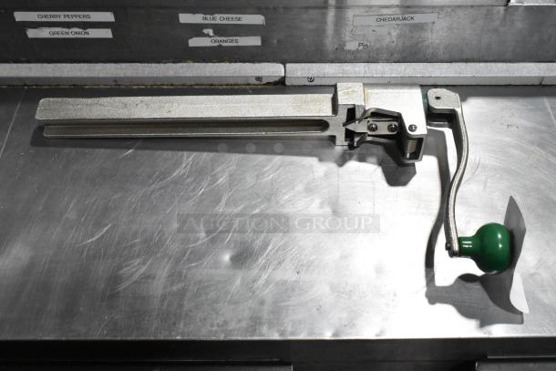 Brand new Garde 407 metal commercial can opener, scratch and dent condition, with green handle on metal countertop.