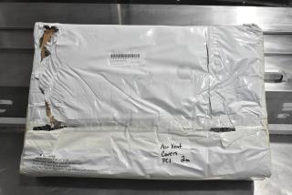 Packaged air vent covers in plastic wrap with visible damage. Handwritten label says "Air Vent Covers PCI 2 ea."