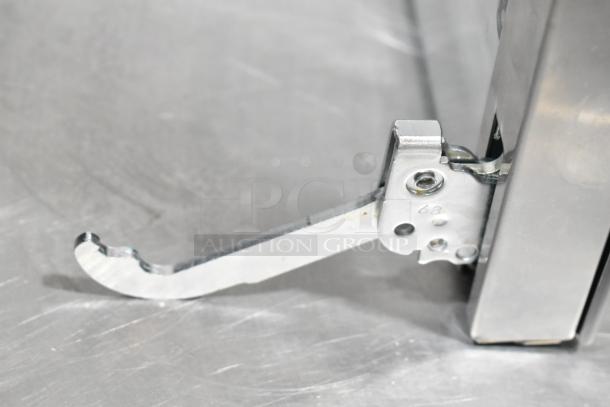 Brand new metal oven door hinge, minor scratches and dents visible, durable stainless steel construction, unmarked.