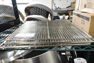 Brand new metal racks, slightly scratched or dented. Sold in sets of four with auction tags visible.