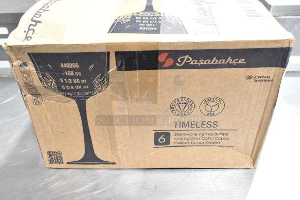 Cardboard box with Pasabahce brand markings, indicating 5.75 oz. Nick and Nora glass, labeled "Timeless," showing signs of wear.