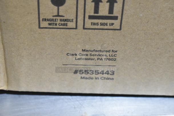 Cardboard box with "Fragile! Handle with Care" and "This Side Up" symbols. Manufactured for Clark Core Services, Lancaster, PA, with item number #5535443, made in China.