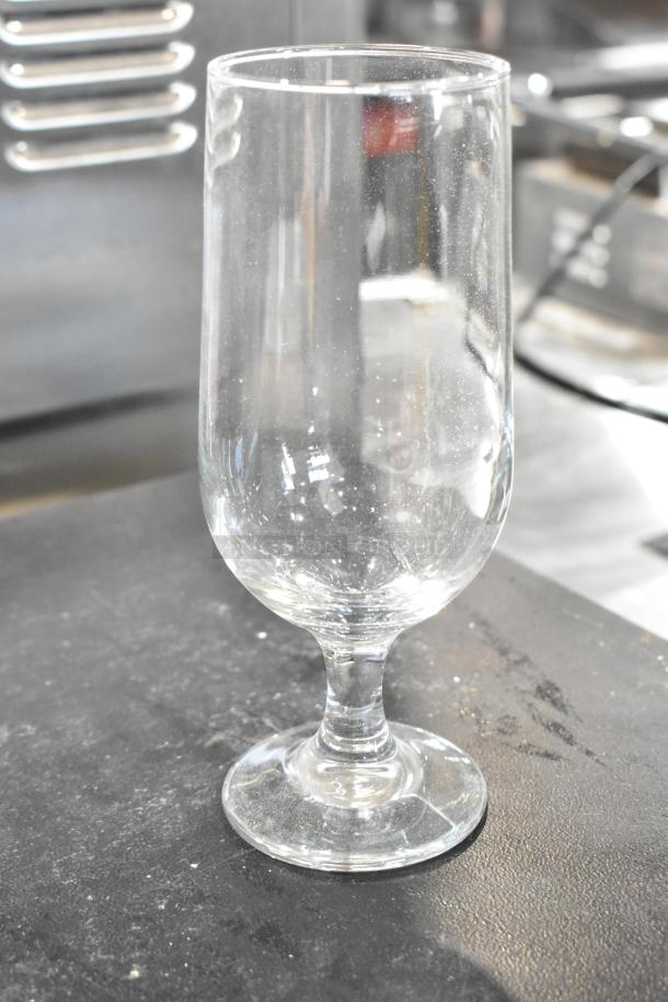 Brand new Libbey Embassy 14 oz. stemmed pilsner glass. Clear glass with a sturdy base, scratch and dent condition.