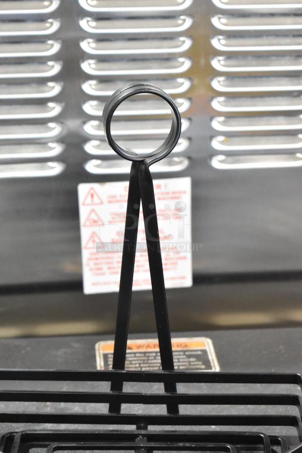 Black metal countertop holder, scratch and dent, new condition, with sturdy design and hoop top. Includes safety warning label.