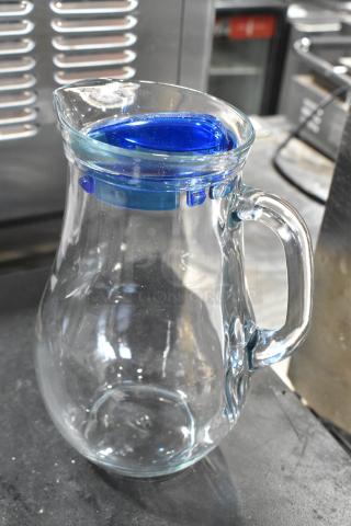 New Pasabahce Bistro glass pitcher, 61 oz, from Steelite International. Scratch and dent condition, clear glass with a blue lid.