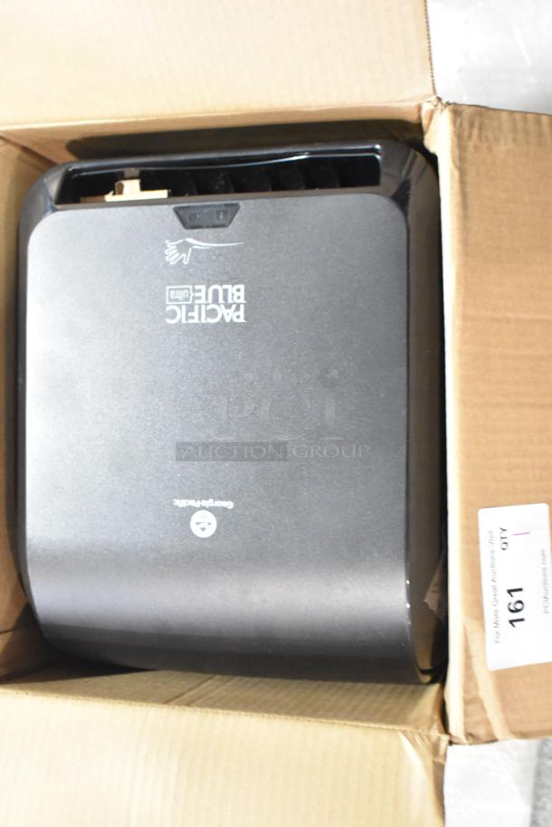 Brand new Georgia Pacific Poly Wall Mount Pacific Blue towel dispenser in box; minor scratches and dents visible.