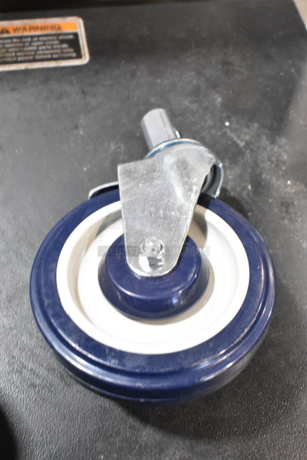 Brand new commercial caster with blue and white wheel, metal bracket, minor scratch.