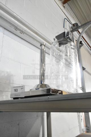 Brand new clear dispenser with minor scratches and dents, stainless steel base, shelf display, item tag 163 visible.