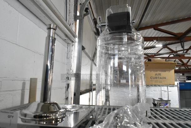 Brand new scratch and dent clear dispenser, stainless steel base, minor surface imperfections.