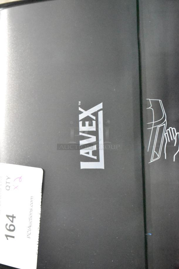 Brand new Lavex black poly wall mount paper towel dispenser with minor scratches and dents, features Lavex logo.
