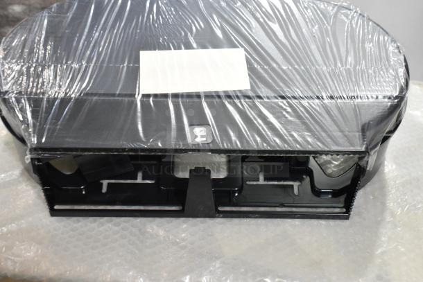 New black poly wall mount toilet paper dispenser, wrapped, in scratch and dent condition, features secure lock access.