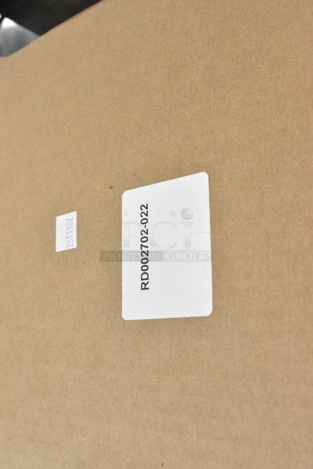 Two new scratch and dent black poly wall mount toilet paper dispensers in original packaging, marked RD002702-022.