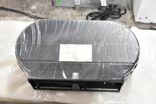 Black poly wall mount toilet paper dispenser, new with slight scratches and dents, wrapped in protective film.