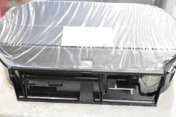 Brand new black poly wall mount toilet paper dispenser, still in packaging. Labeled as scratch and dent condition.
