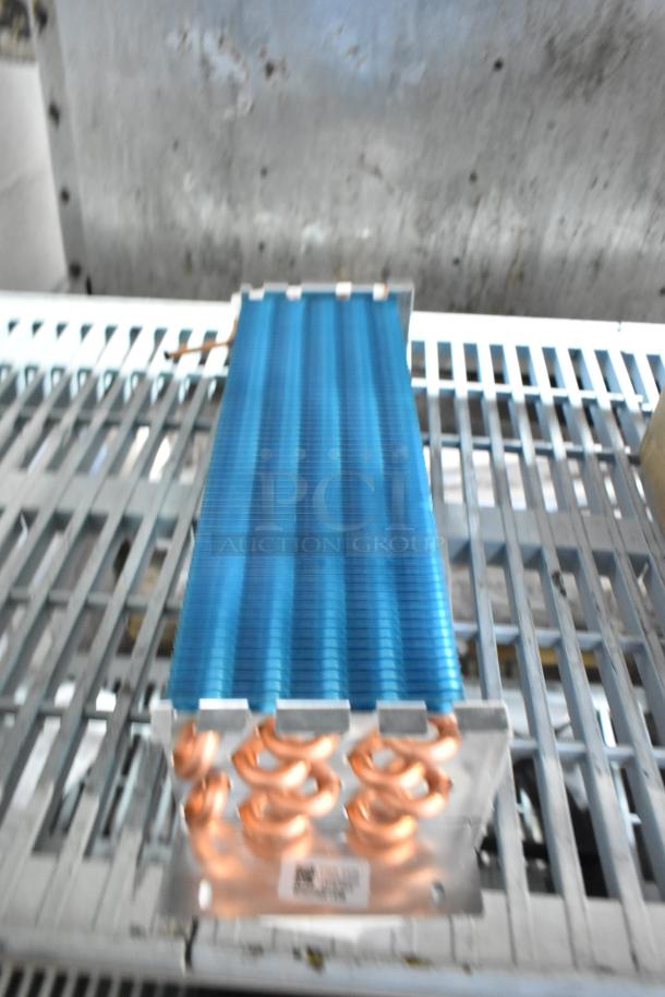 Brand new Avantco 17815282HC evaporator coil for A-12 refrigerators, featuring copper coil and blue fins. Scratch and dent condition.