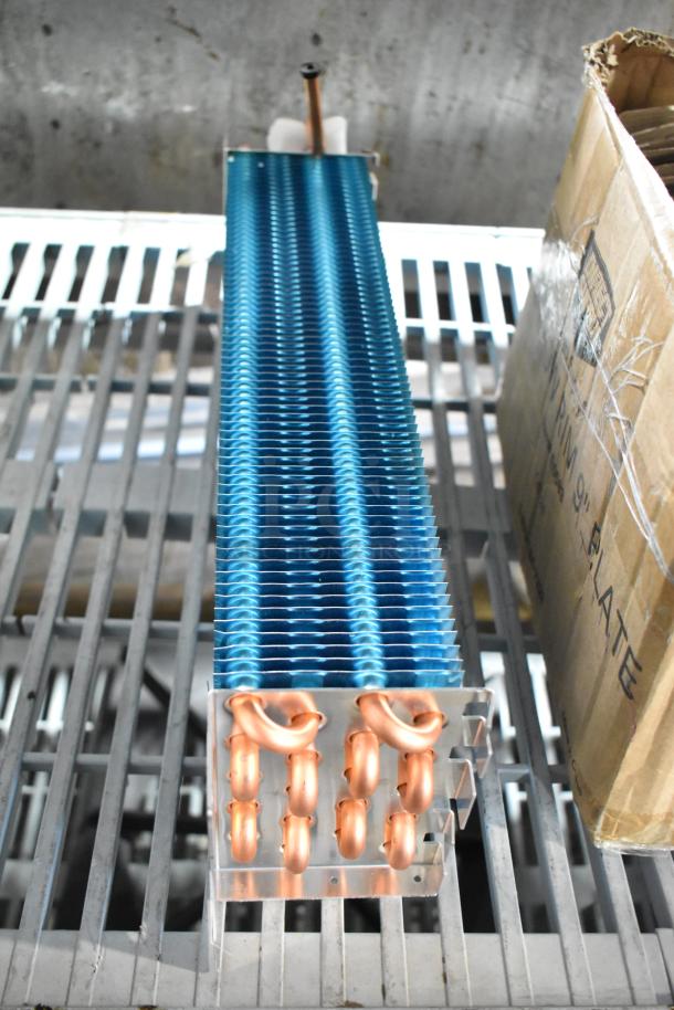 Brand new Avantco 17815282HC evaporator coil for A-12 refrigerators, slight scratches, highlights copper tubing and blue fins.