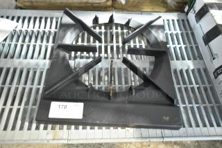 BRAND NEW SCRATCH AND DENT single burner range grate. Features a robust metal build, slight imperfections present. Quantity tag visible. Ideal for stove replacement.