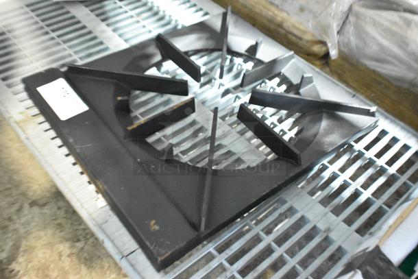 Brand new single burner range grate, scratch and dent condition, black finish, sturdy design, visible label on the side.