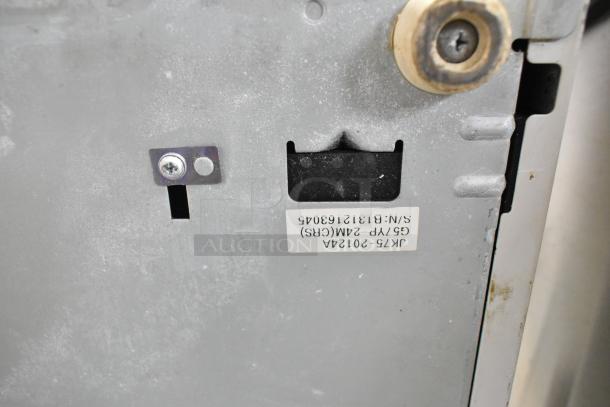 Sam4S ER-521SM cash register casing detail with visible label showing model and serial number. Some wear evident on surface.