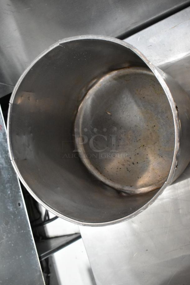 Five assorted metal stock pots in used condition, showcasing visible wear. Ideal for bulk cooking or catering.