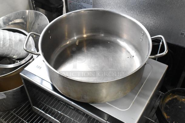Five metal stock pots in used condition, various sizes. Visible handles and slight wear. Perfect for versatile cooking uses.