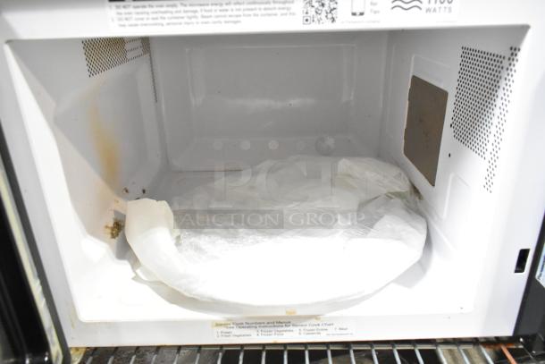 Panasonic NN-SU696S countertop microwave, 115 volts, inside view showing wear and included glass plate, used condition.