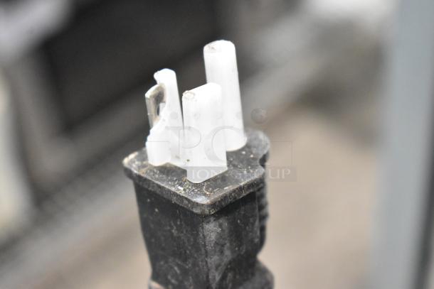 Broken plug from a Mainstreet 541CHP1836I cabinet. Textured, black casing with visible debris.