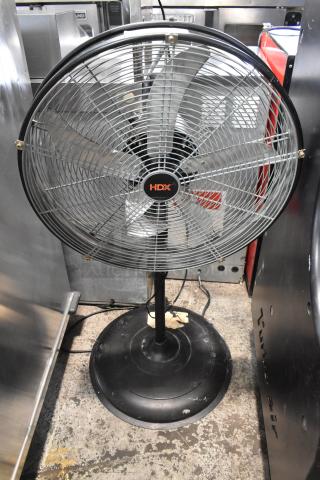 HDX SFSD1-500B3W metal floor fan, 120V, 1 phase, black stand, visible signs of wear, ideal for industrial use.