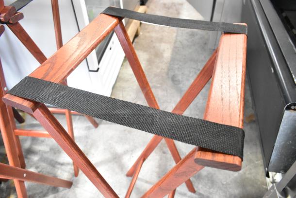 Four wooden folding serving tray stands with black straps, in excellent condition, perfect for versatile use and easy storage.