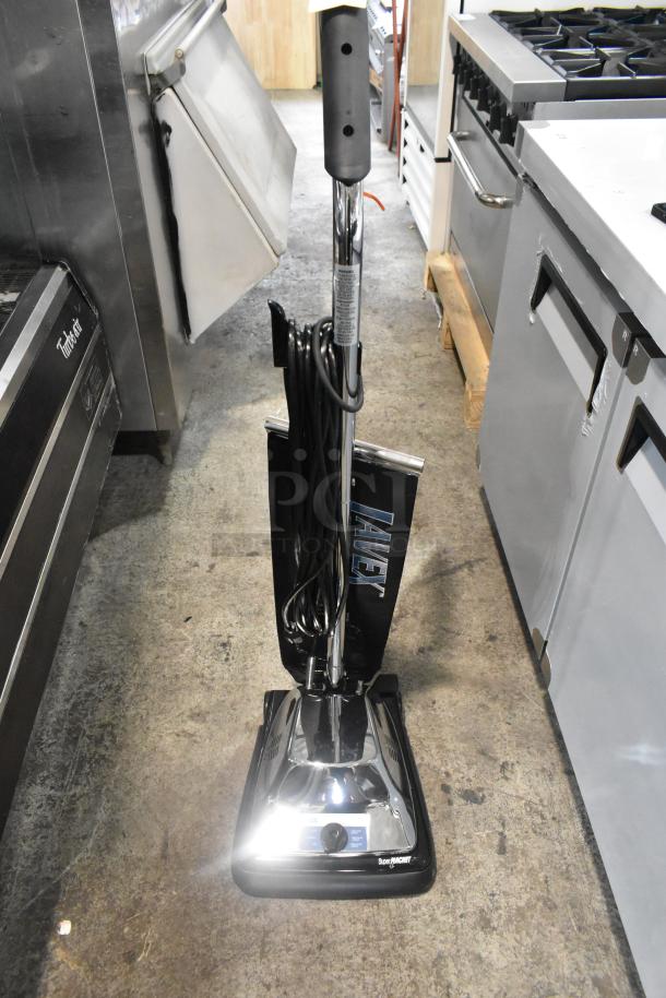 Lavex P101 Vacuum Cleaner, 120V, 1 Phase, upright model, black with chrome details, visible cord wrap, in used condition.