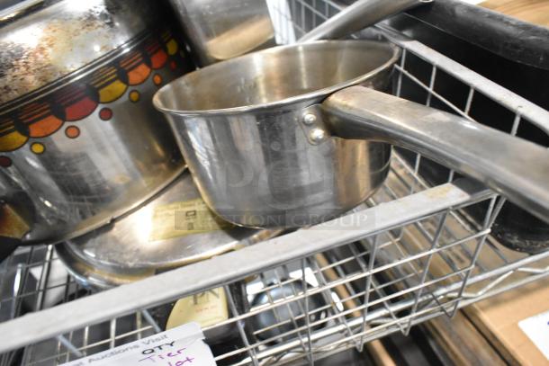 Tier lot with a metal saucepan, patterned pot, and poly bus bin. Features include visible wear and auction label.