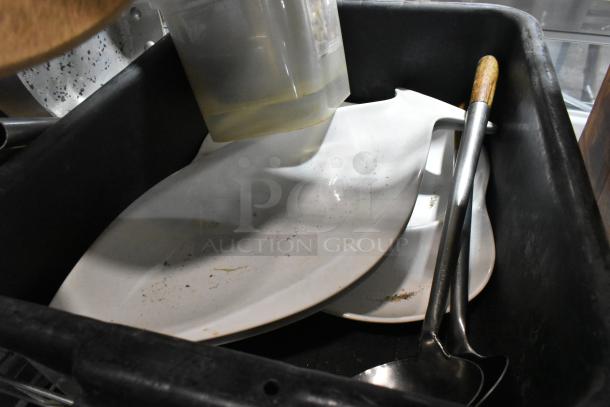 A tier lot of various kitchen items including a sauce pan and poly bus bin, with dishes and ladles in a used condition.