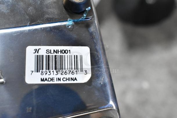 Metal countertop napkin dispenser with "SLNH001" label, barcode, and "Made in China" text. Appears in good condition.