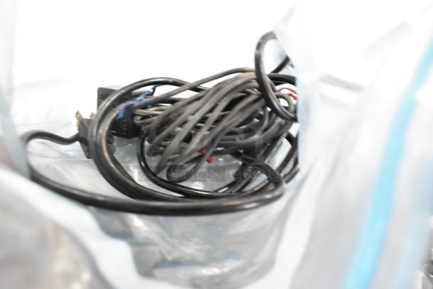 A tangled bundle of black cables, possibly related to a Brother MFC-7360N printer, with visible power plug in a plastic bag.