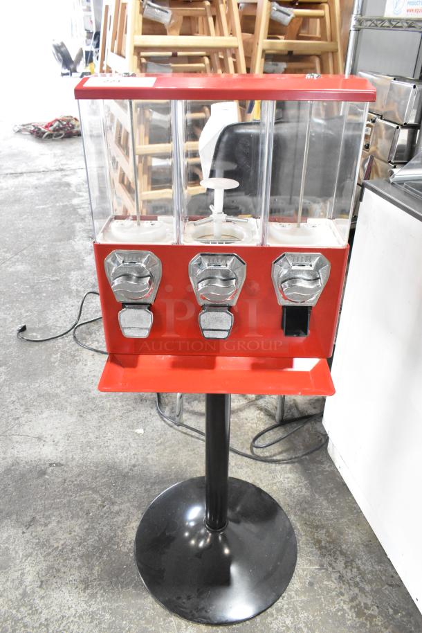 Metal 3 compartment vending machine with coin slots, red and black stand, clear compartments for inventory viewing, good condition.