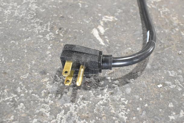 A black electrical plug attached to the True TDC-87 ice cream dipping cabinet, 115 volts, used.
