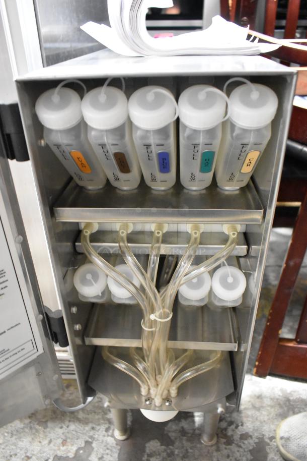 SureShot ACFS-10 stainless steel flavor dispenser, 120V, 1 Phase, countertop model. Six flavor bottles with tubes shown.
