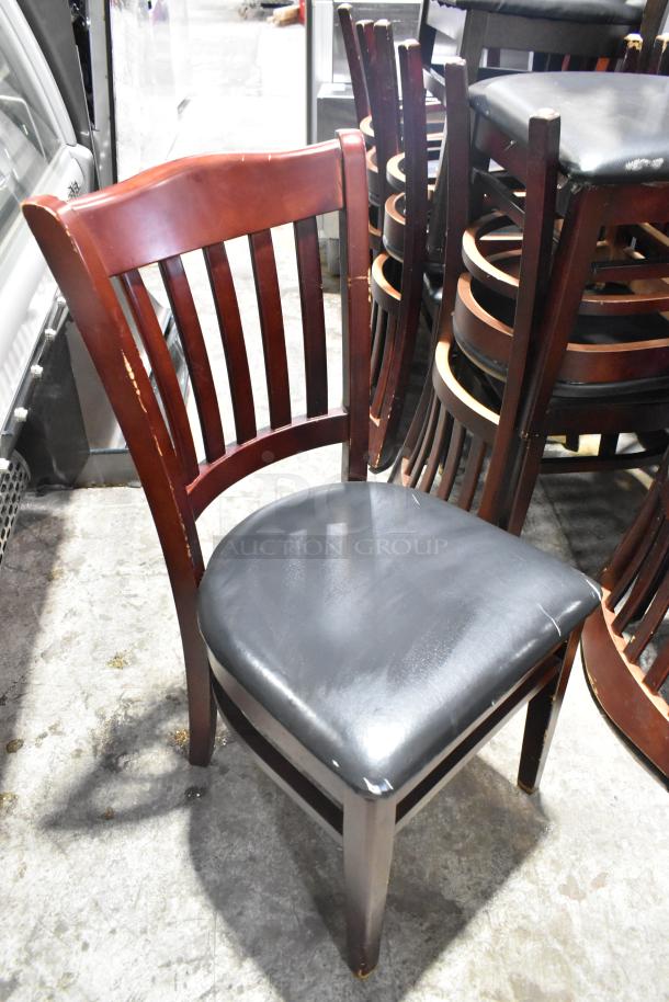 Wooden dining chair with black seat cushion, slight wear, high backrest, sturdy construction. Auction for 14 pieces.
