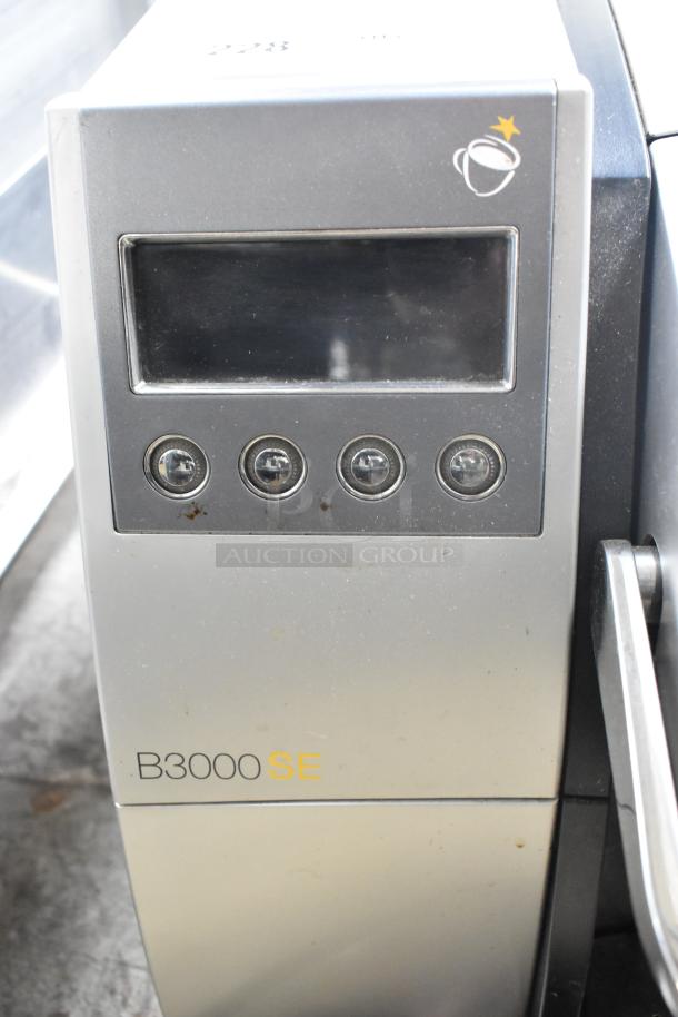 Keurig B3000SE single cup coffee machine, silver and black, showing control panel and buttons. Model label visible.