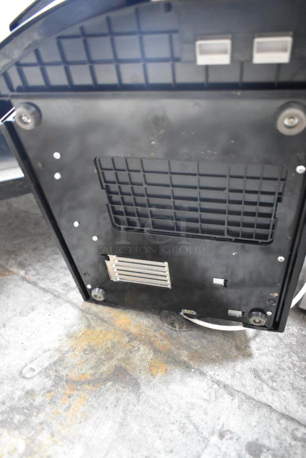 Keurig B3000SE single cup coffee machine, underside view, showing filter vents and screws. 120 volts, 1 phase.