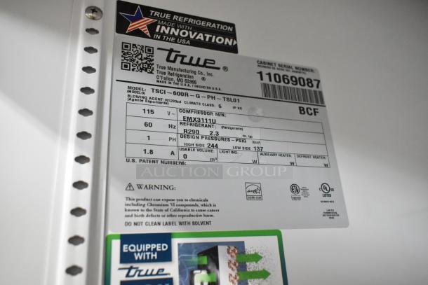 BRAND NEW True TSCI-600R-G-PH reach-in cooler with poly-coated racks, 115V, 1-phase; label shows specs and energy certifications.