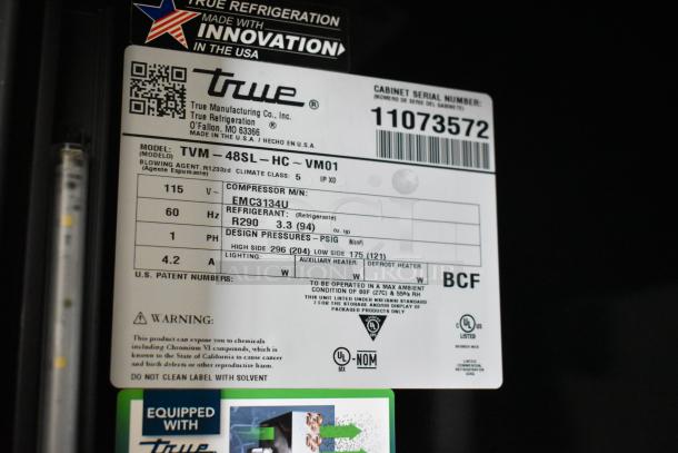 Label showing True TVM-48SL-HC cooler specifications: 115 volts, 1 phase, model details, and refrigerant type R290.