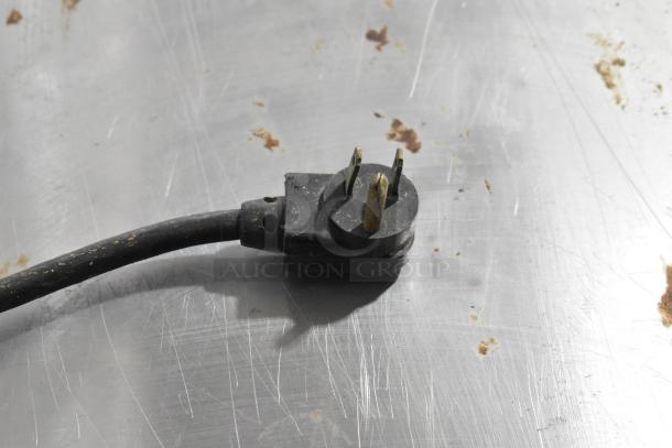 Power plug detail of True TUC-27 Undercounter Cooler, showing a three-prong connector on a stainless steel surface.