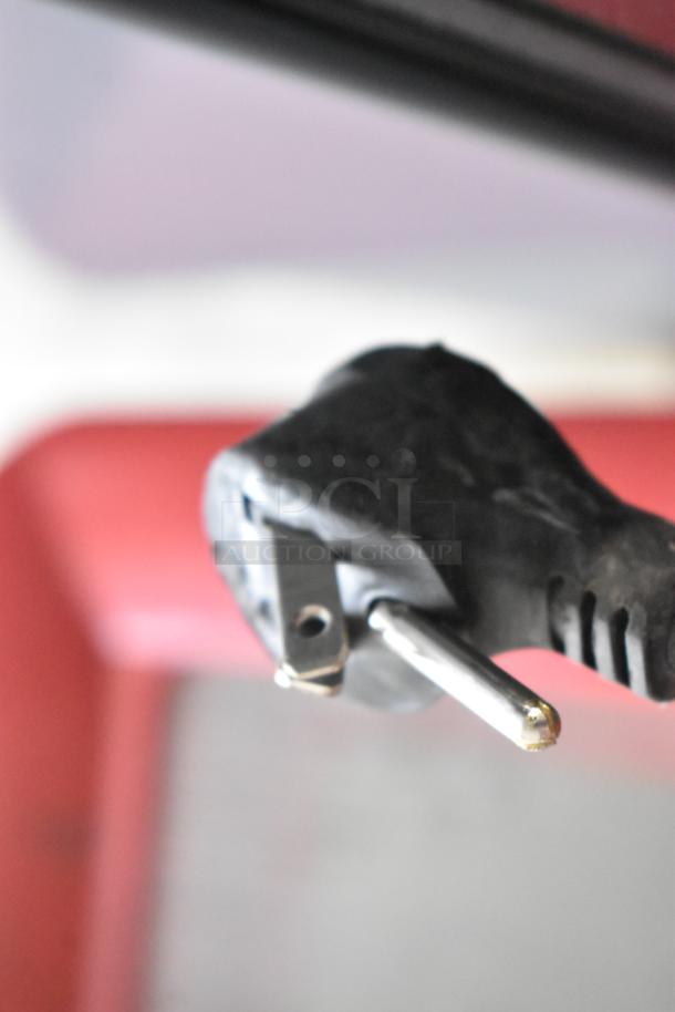 Close-up of a 115V power plug for a True GDM-12-HC commercial cooler. Black plastic with metal prongs, indicating electrical hookup.