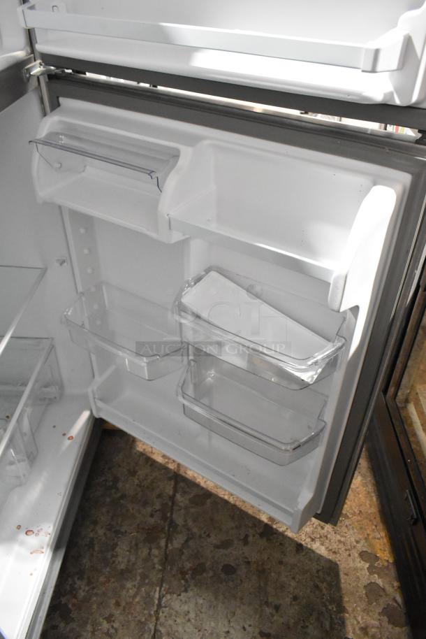 BRAND NEW SCRATCH AND DENT! 2025 Whirlpool WRT311FZDM05 stainless steel cooler with freezer, 115 volts, 1 phase. Interior view showcasing shelves and compartments.